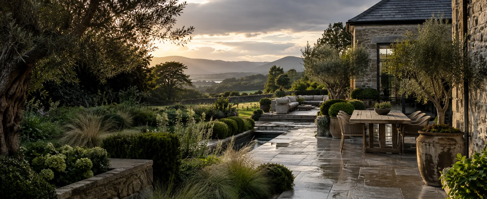 Limestone terrace and planted garden by a stone house